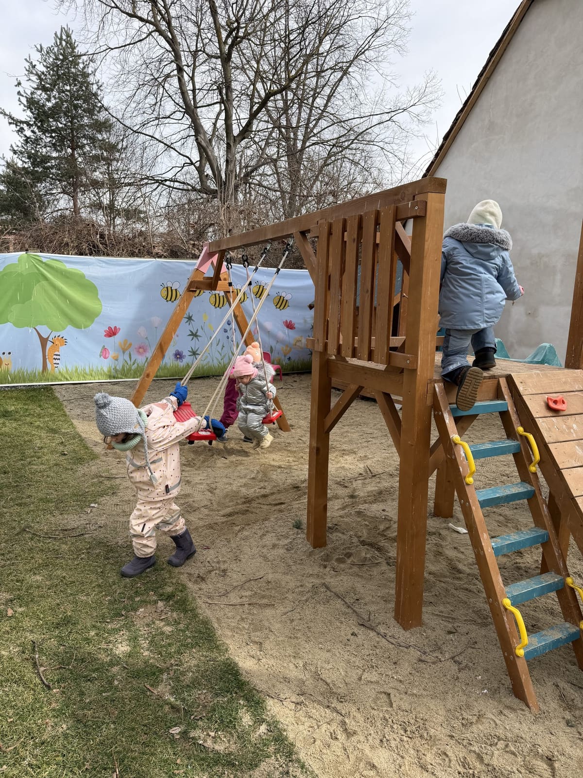 Copii explorând locul de joacă din lemn